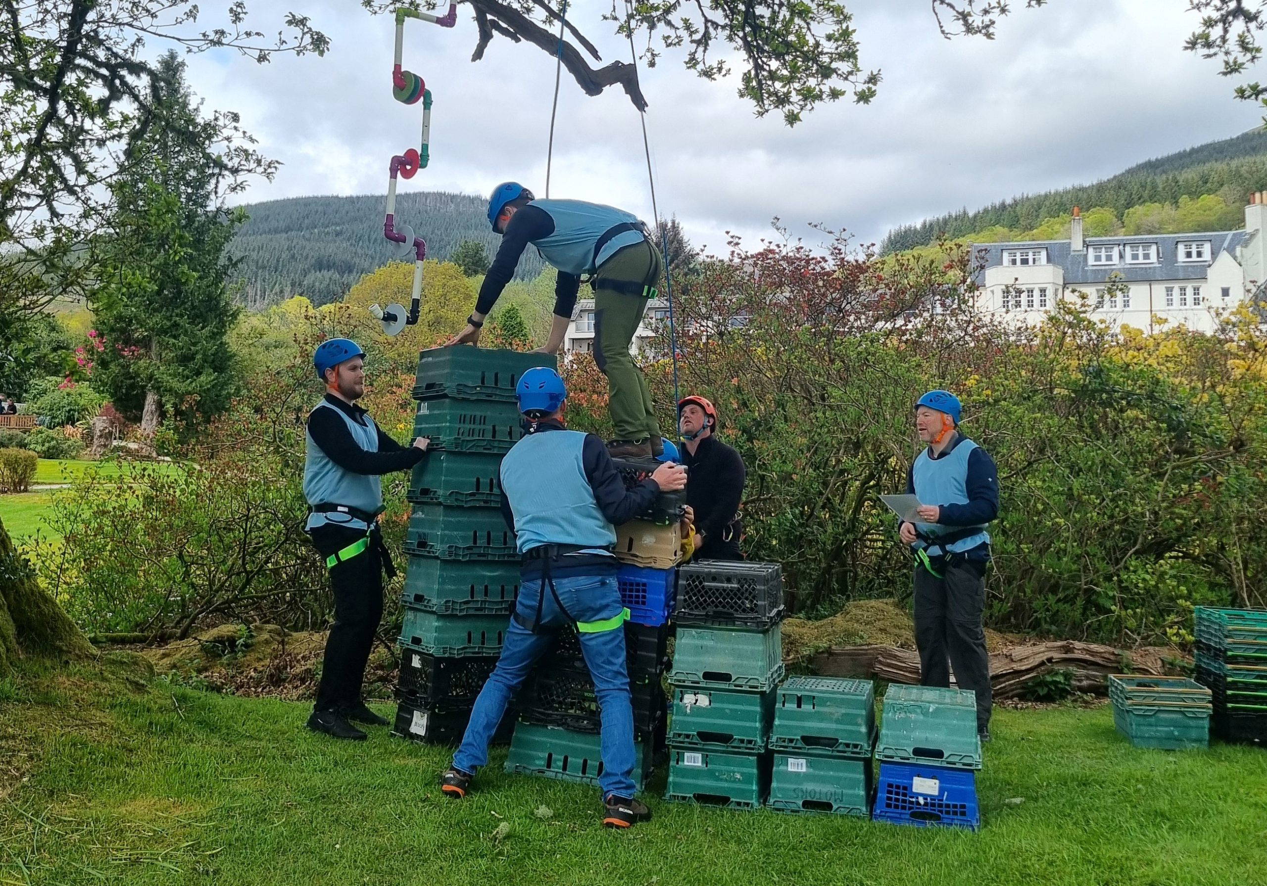 Team Building Group climbing crates under a tree